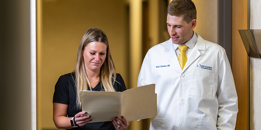 Dr Davidson reviewing oral pathology reports with an assistant